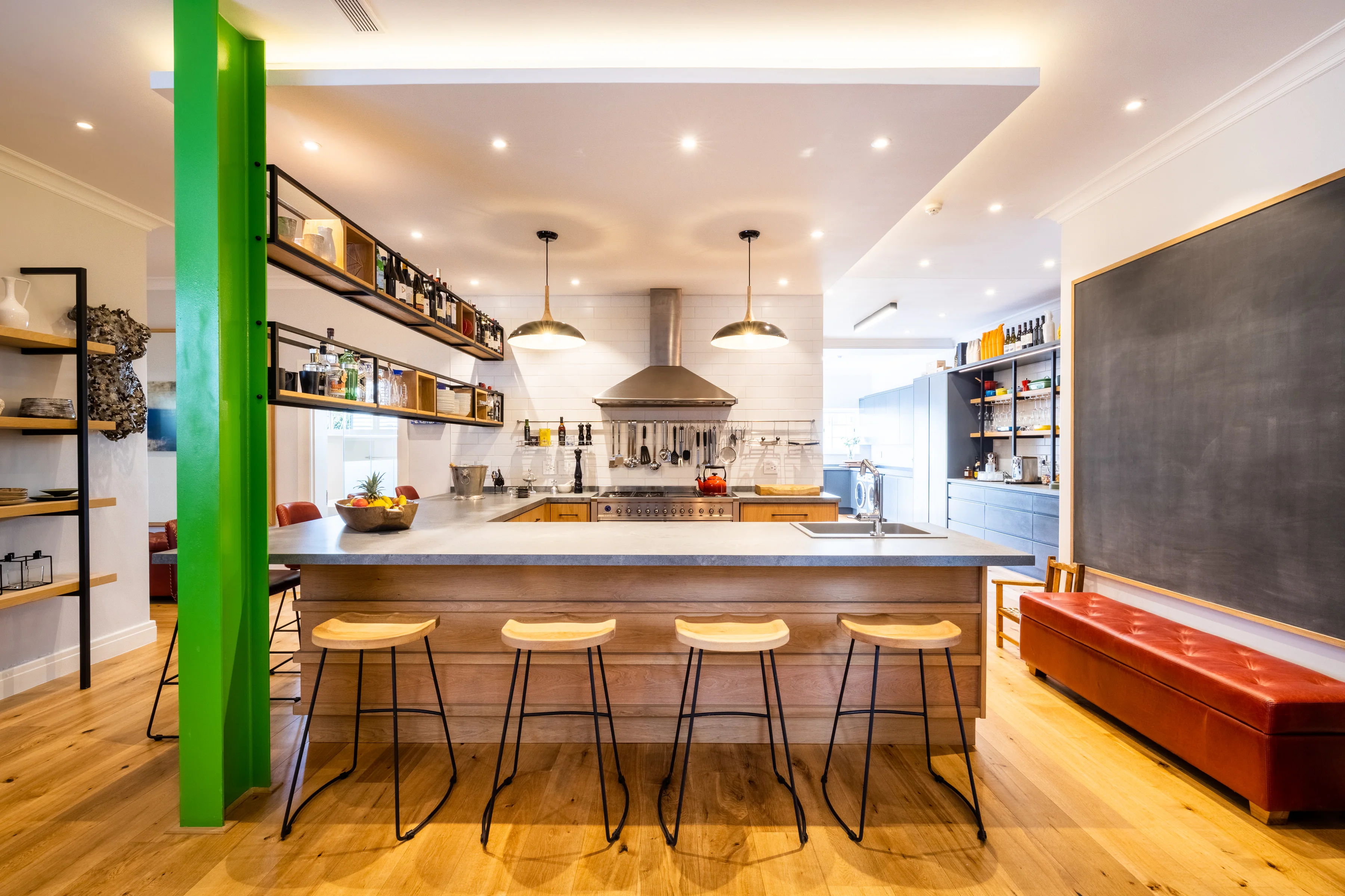 The kitchen: gas range at the centre, open shelves to the left, the chalkboard beyond